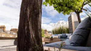 Angolo relax con divani e cuscini su una veranda verde con vista sui tetti