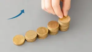Mano che impila monete accanto a pile ordinate in crescita
