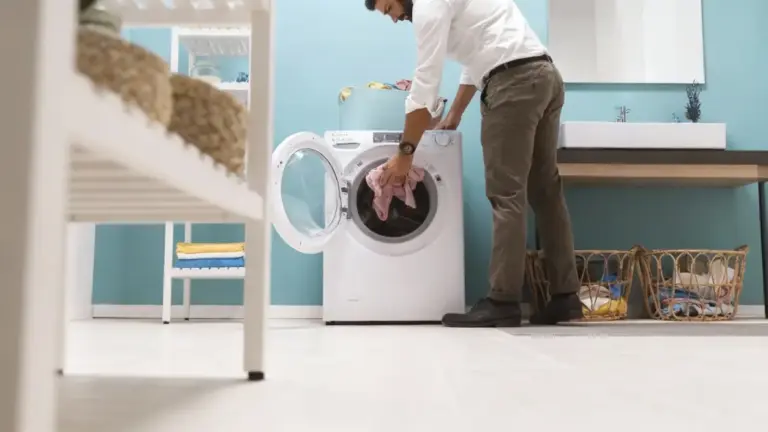 Persona che carica lana rosa in lavatrice in un ambiente domestico ordinato