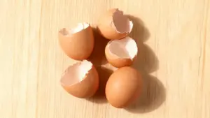 Gusci d'uovo rotti su una superficie di legno chiaro