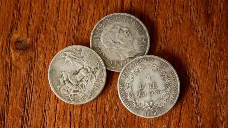 Tre monete rare italiane in argento su sfondo di legno