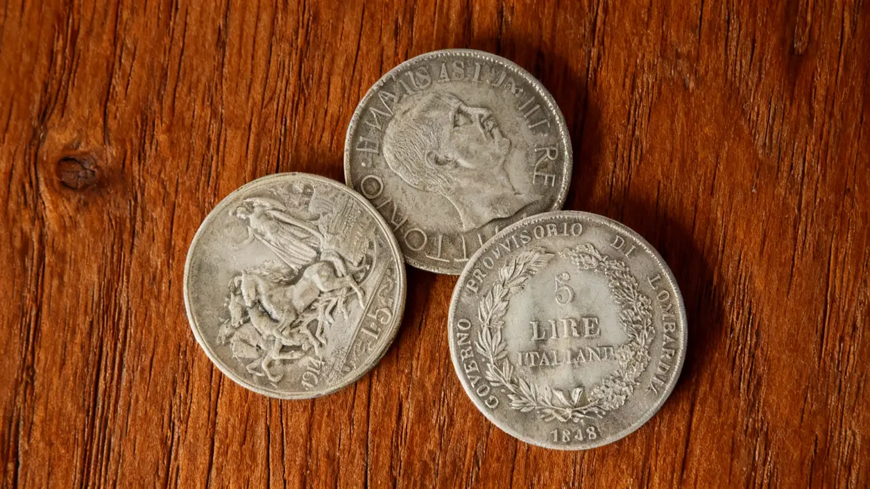 Tre monete rare italiane in argento su sfondo di legno