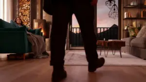 Interno accogliente con divani, camino acceso e vista su montagne al tramonto