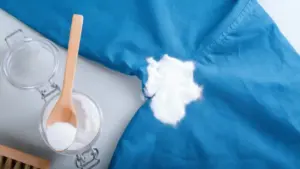 Polvere bianca naturale usata su una maglietta blu per rimuovere macchie di sudore