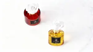 Due diffusori di profumo per ambienti con fiore decorativo su fondo bianco.