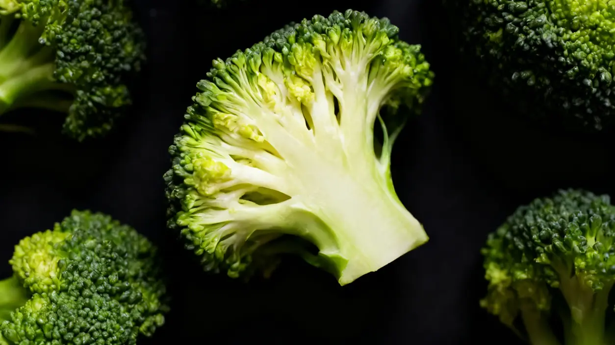 Primo piano di cimette di broccoli freschi su sfondo scuro