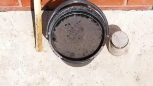 Secchio e barattolo pieni di cenere su una superficie di cemento