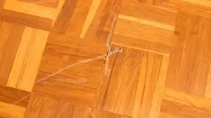 Pavimento in parquet con profondi graffi e segni visibili sul legno