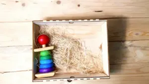 Giocattolo di legno colorato in una scatola su fondo di legno chiaro