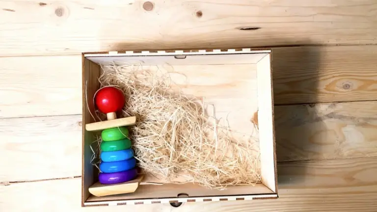 Giocattolo di legno colorato in una scatola su fondo di legno chiaro