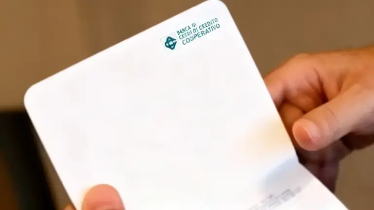 Una persona tiene in mano un vecchio libretto bancario della Banca di Credito Cooperativo