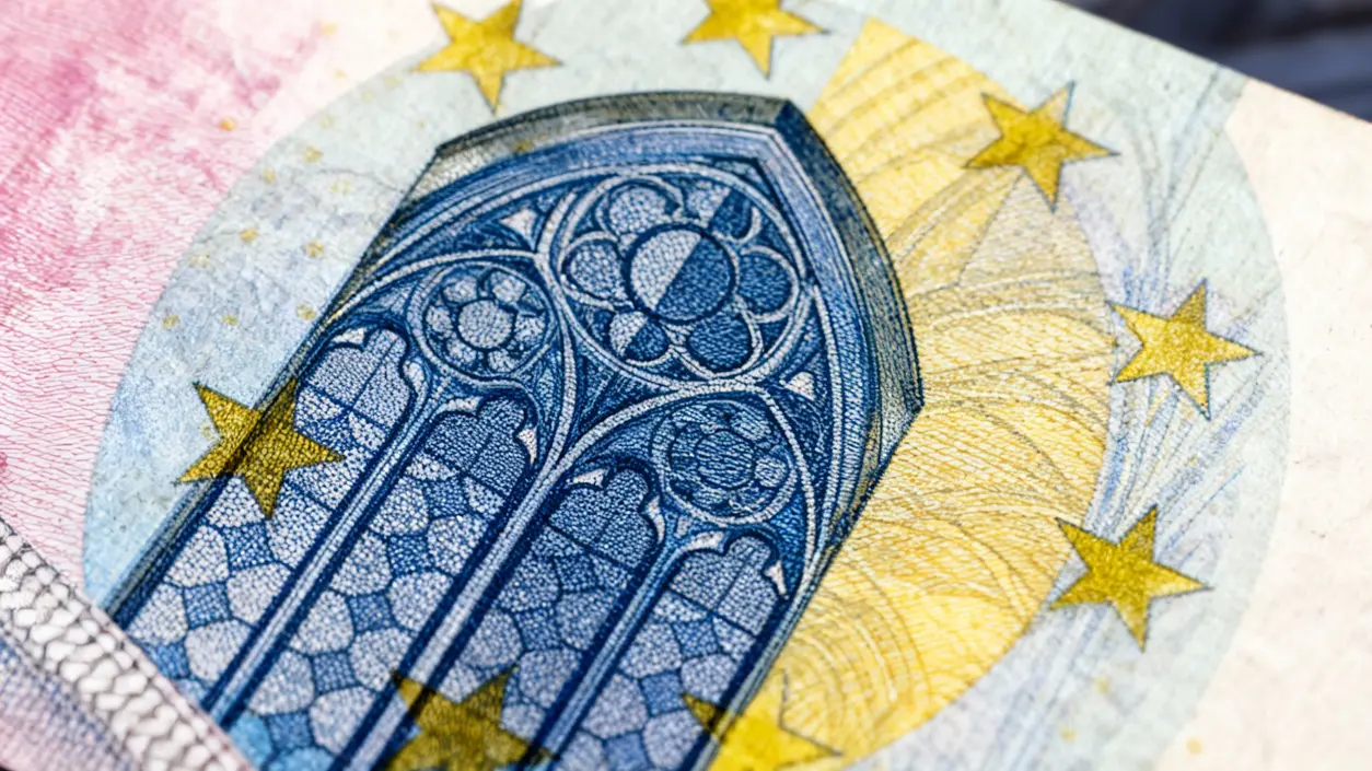 Dettaglio ravvicinato di una vecchia banconota in euro con elementi architettonici e stelle dorate